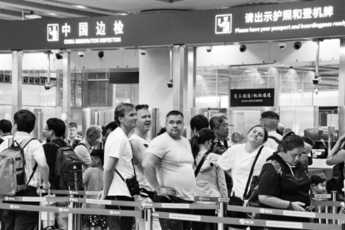 7月10日,国外旅客在北京首都机场边防检查站办理手续。新华社发